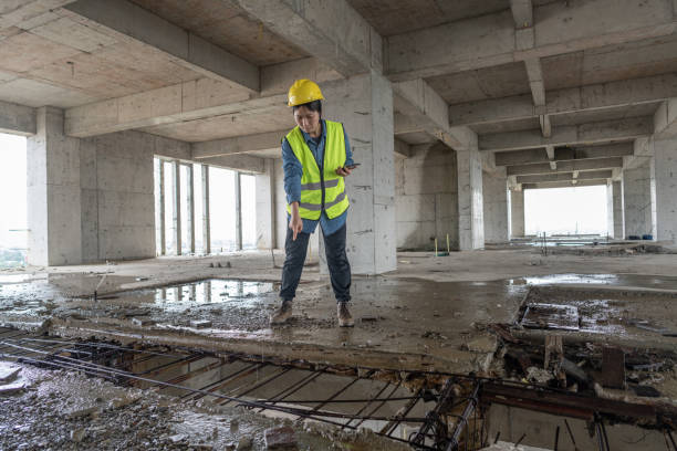 An Asian female engineer was checking the water leakage at the building site An Asian female engineer was checking the water leakage at the building site